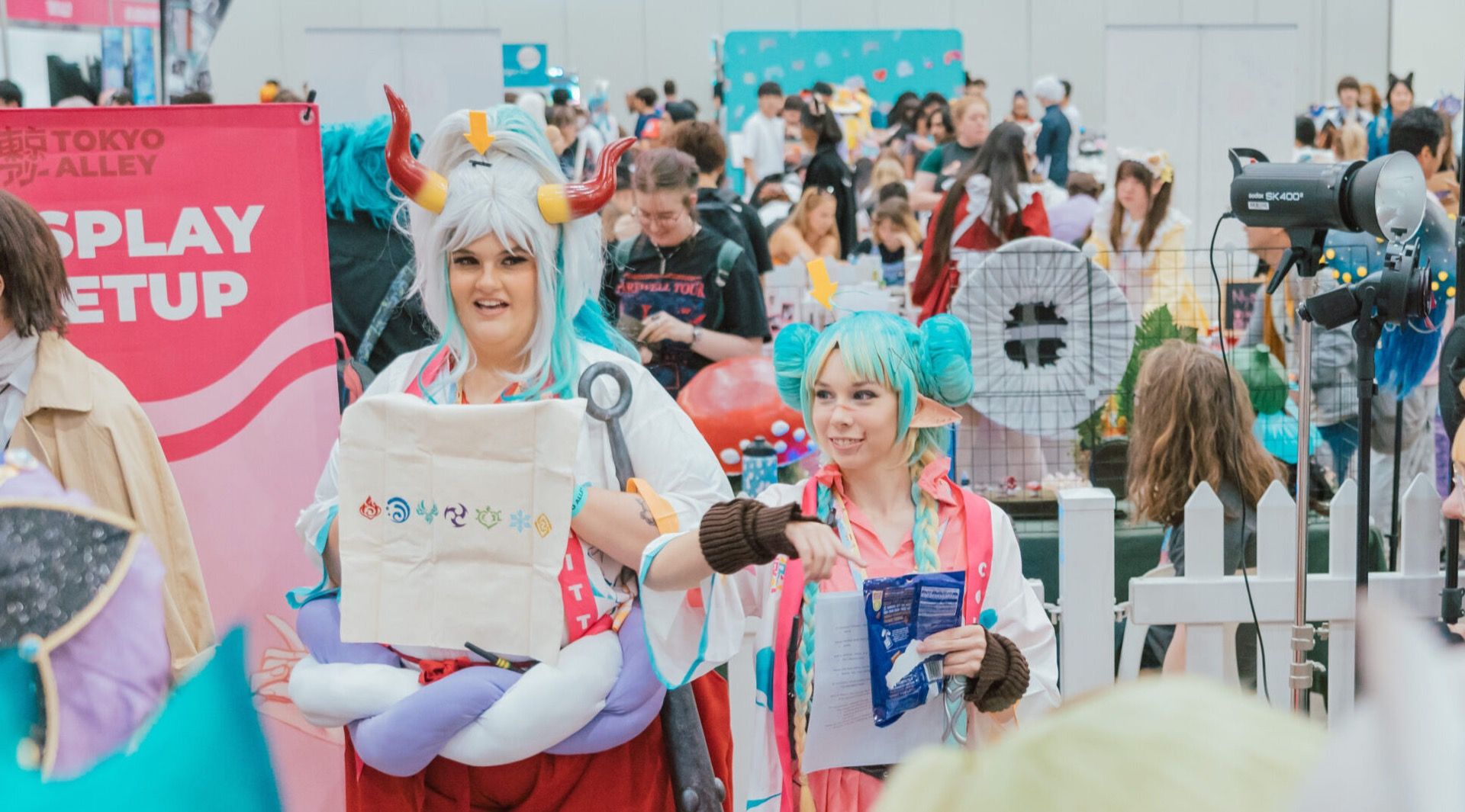 Cosplayers holding a Tokyo Alley tote bag